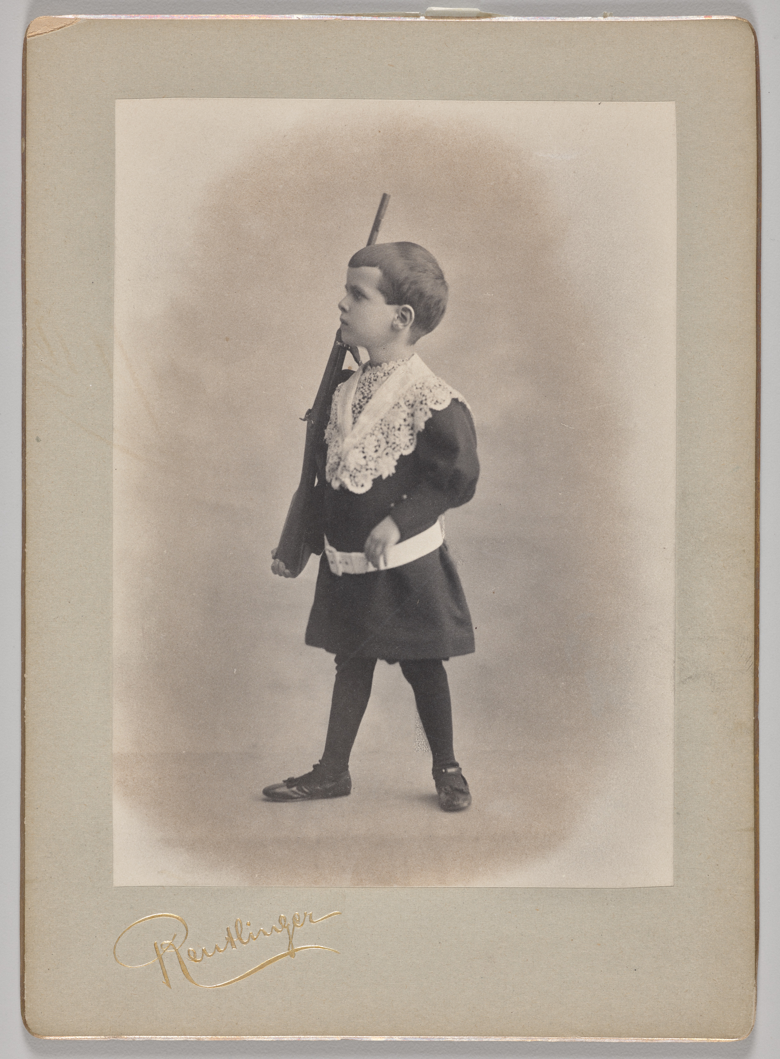 Untitled (young boy with lace collar and toy rifle)